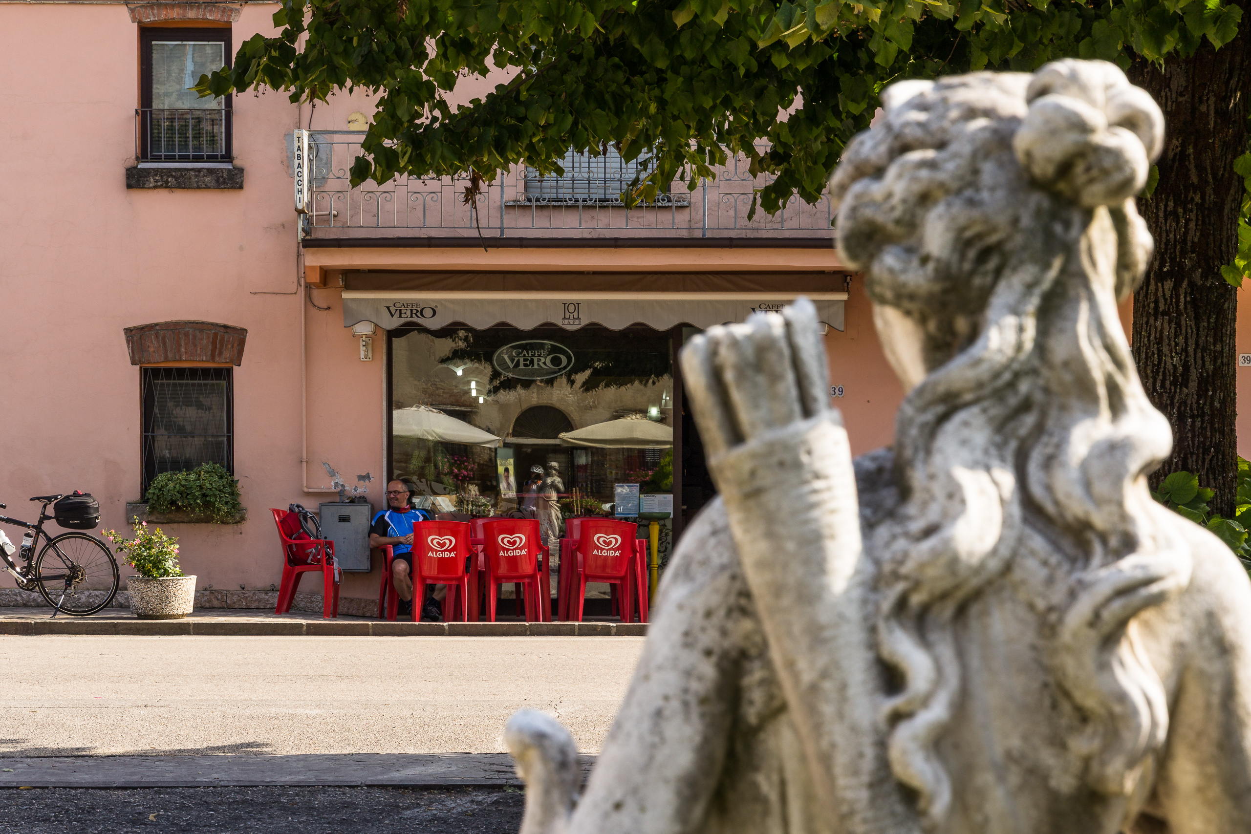 Rast am Caffè Vero – rote Stühle vor der Tabaccheria